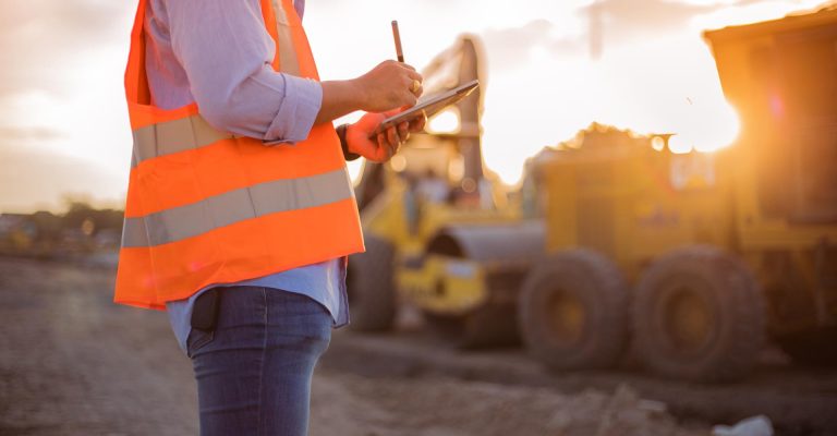 Asian engineer with hardhat using  tablet pc computer inspecting